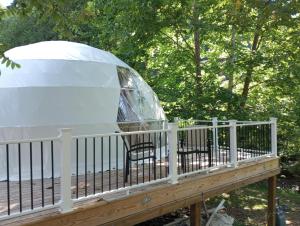 iglú en una terraza con mesa y silla en GlampOut Resort - Elk River en Sutton