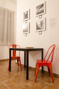 una mesa con 2 sillas y cuadros en la pared en Downtown Lodge Museum, en Taranto