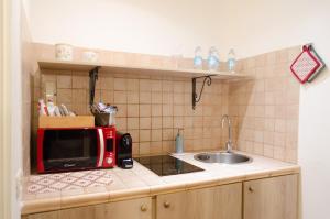 a kitchen with a sink and a red microwave at Downtown Lodge Museum in Taranto