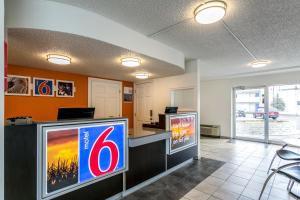 a lobby with a television and a counter with a sign at Motel 6-Butte, MT - Historic City Center in Butte