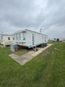 a mobile home is parked in a yard at Ingoldmells -Caravan- Sleeps 6 - Seaside - Parking in Skegness