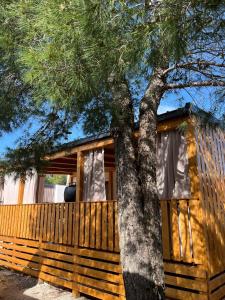 uma cabana de madeira com uma árvore em frente em Getaway Mobile Home em Drage