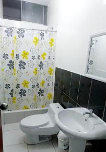 ein Badezimmer mit einem Waschbecken, einem WC und einem Duschvorhang in der Unterkunft Hotel Loma Hermosa in Piura
