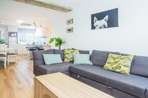 a living room with a blue couch and a kitchen at CARTAGENAFLATS, Apartamentos Anfiteatro Romano in Cartagena