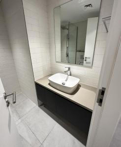 a white bathroom with a sink and a mirror at Private Room in a Shared Apartment in Sharjah