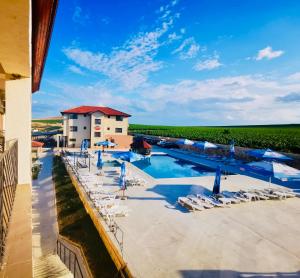 Blick auf den Pool in einem Resort mit Liegestühlen in der Unterkunft Pensiunea Fabian in Jurilovca