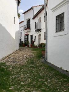 a cobblestone alley between two white buildings at ALOJAMIENTO RURAL EL CASTAÑO in Fuenteheridos