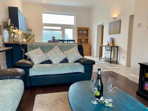 ein Wohnzimmer mit einem Sofa und einem Tisch in der Unterkunft Rushcroft Farm Cottages in Sway