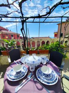 uma mesa com pratos e copos numa toalha de mesa roxa em -La Terrazza nel Vigneto- [Golfo dei Poeti] em Tellaro