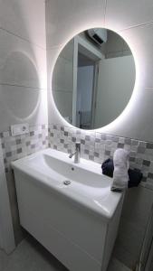 Baño blanco con lavabo y espejo en FUENGIROLA CENTRO, en Fuengirola