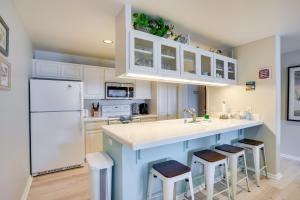a kitchen with white cabinets and a blue island with stools at Gorgeous Catalina Island Condo with Golf Cart! in Avalon