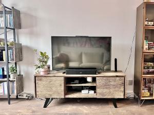 a television on a wooden entertainment center in a living room at Beautiful Luxury Shared Home in Montreal in Montreal