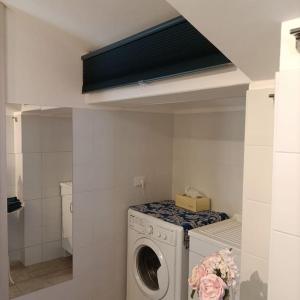 a washer and dryer in a room with at The Bays - La Mansarda ad un passo dal mare in Acireale +32 photos