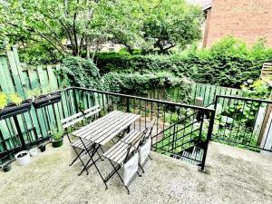a wooden table and chairs on a balcony with a fence at Beautiful Luxury Shared Home in Montreal in Montreal