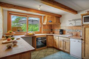 a kitchen with wooden cabinets and a window at Chalet Arsene et Lea - OVO Network in Manigod