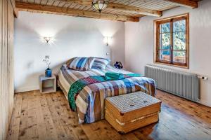 a bedroom with a large bed and a window at Chalet Arsene et Lea - OVO Network in Manigod