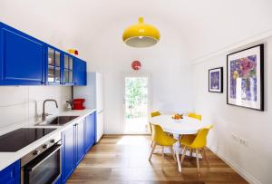 a kitchen with blue cabinets and a table with yellow chairs at Villa - La Formica Gentile - Monopoli in Gorgofreddo