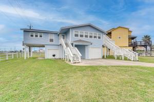 una casa azul con escaleras blancas en un patio en Modern Freeport Home with Views Walk to Beach!, en Freeport