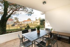 uma mesa e cadeiras numa varanda com vista em Le Bonamour em Capbreton