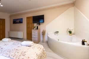 a white bathroom with a tub and a sink at Balaton Fantasy Villa in Balatonfüred