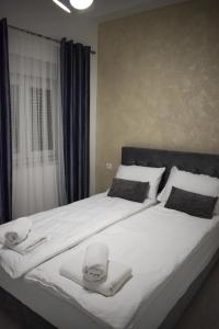 1 dormitorio con 1 cama grande y toallas. en Amal en Mostar