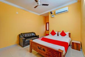 sypialnia z łóżkiem i skórzanym krzesłem w obiekcie OYO 82990 DHANAS BEST AMBIENCE w mieście Puducherry