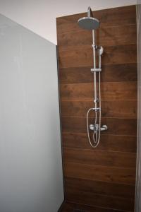 y baño con ducha y pared de madera. en Amal en Mostar