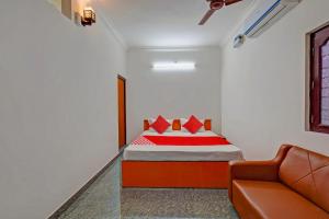 ein kleines Schlafzimmer mit einem Bett und einem Sofa in der Unterkunft OYO 82990 DHANAS BEST AMBIENCE in Puducherry