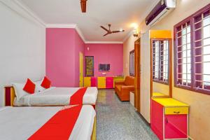 kolorowy pokój hotelowy z 2 łóżkami i kanapą w obiekcie OYO 82990 DHANAS BEST AMBIENCE w mieście Puducherry
