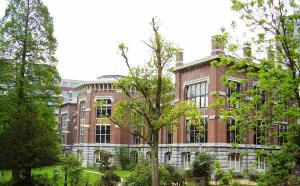 un edificio de ladrillo con árboles delante de él en Belle appartement commission européenne, en Bruselas