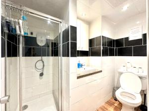 a bathroom with a shower and a toilet and a sink at Kings Cross Guest House in London