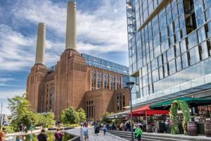 a large brick building with two smoke stacks in a city at Luxury Collection Riverside in London