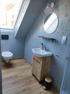 ein Badezimmer mit einem Waschbecken, einem WC und einem Spiegel in der Unterkunft Nowe Apartamenty na Światowida VITO APARTMENTS in Misdroy