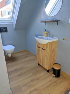 a bathroom with a sink and a toilet at Nowe Apartamenty na Światowida VITO APARTMENTS "centrum"molo 5 min spacerem" in Międzyzdroje