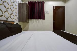 a bedroom with a large white bed and a door at Mumbai Residency in Mumbai