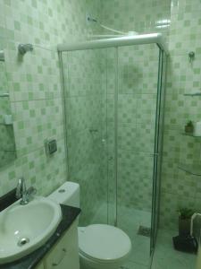 a bathroom with a shower and a toilet and a sink at Apto 348 centro nucleo bandeirante in Núcleo Bandeirante