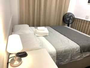 a bedroom with a bed and a table with a lamp at Apartamento inteiro no 15º andar próximo ao aeroporto de Guarulhos GRU in Guarulhos