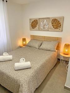 a bedroom with a bed with two towels on it at Reformado. Plaza de Toros. A/C in Alicante