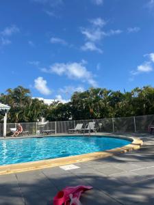 a swimming pool with two chairs and a pink animal next to it at Azuri Lodge Piscine Privée Marina Golf in Saint-François