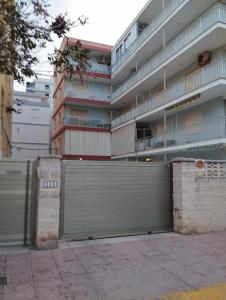 un gran edificio con una puerta y un garaje en Apartamento Bonanza, Playa de Gandía, en Los Mártires