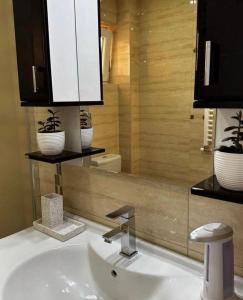 a bathroom with a white sink and a mirror at L&D apartman in Kruševac +25 photos