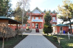 a red brick building with a pathway in front of it at Шинам Мехмонхонаси in Eshonguzar