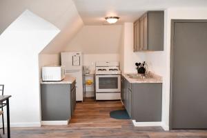 Unwind in a Bright Comfortable Apartment for 3 في بيتسبرغ: مطبخ مع الأجهزة البيضاء والأرضيات الخشبية