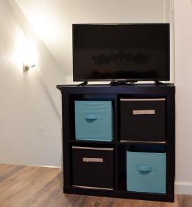 a black entertainment center with a flat screen tv on it at Unwind in a Bright Comfortable Apartment for 3 in Pittsburgh