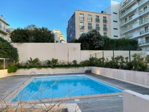 einen Pool in einem Apartment mit Gebäuden in der Unterkunft Le Coquillage - 200 mètres de la Plage in Cannes