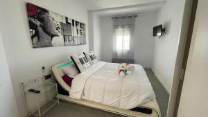 a bedroom with a bed with a teddy bear on it at Casa con acceso directo a la playa de Mojácar in Mojácar