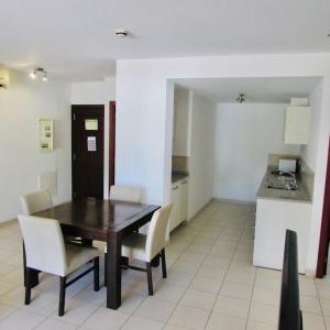 a kitchen with a wooden table and chairs in a room at Coastal Comfort at Tortuga Beach - 292 in Prainha