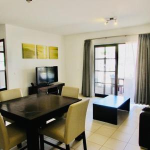 a living room with a dining room table and chairs at Coastal Comfort at Tortuga Beach - 292 in Prainha