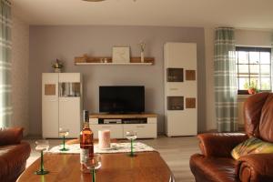 a living room with a couch and a table with wine glasses at Ferienwohnung Mietzner in Laubach
