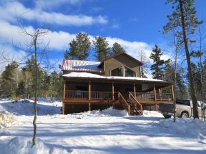 una baita di tronchi nella neve con un camion parcheggiato di fronte di Triple R Retreat at Terry Peak a Lead